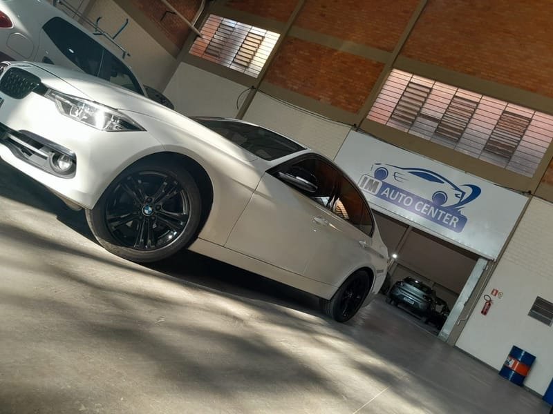 Fachada da IM Auto Center, com o letreiro da oficina e um carro na área de serviço